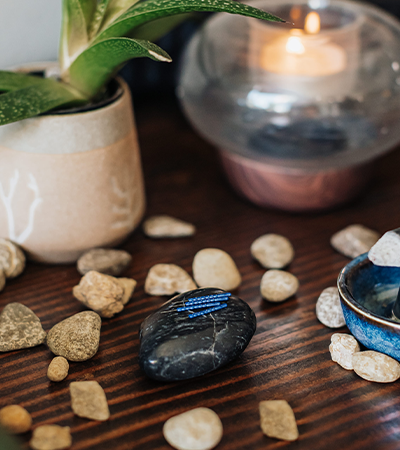 Pure Health Alliance, Image of table with rocks and acupuncture needles and plant.